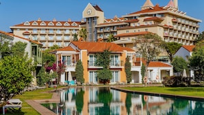 A hotel with a swimming pool, multiple balconies, and a clock tower. - IC Hotels Santai Family Resort - All Inclusive (Serik)