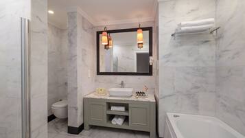 A modern bathroom with a white sink, vanity, and bathtub.