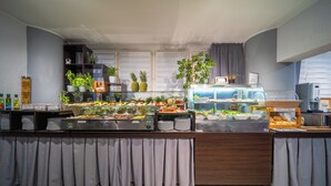 A buffet setup with various food items and a display case.