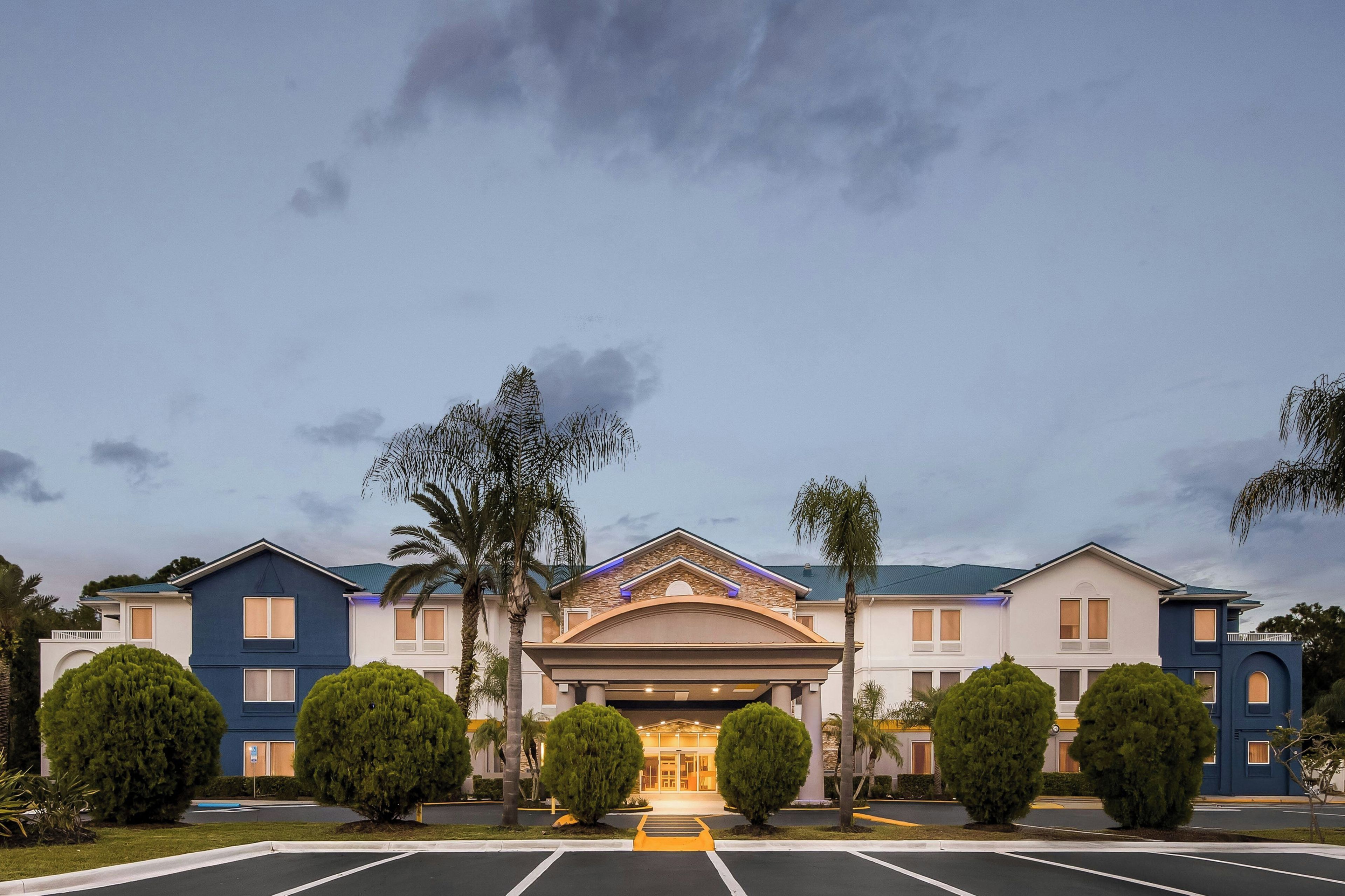 A hotel with a symmetrical facade, multiple windows, and a central entrance.