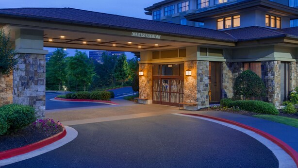A hotel entrance with a stone facade, a covered driveway, and a clear view of the parking area. - Hilton Garden Inn Atlanta Marietta (Atlanta)