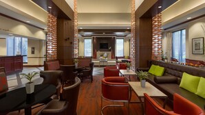 A spacious lobby with a central seating area, a reception desk, and a large window providing natural light. - Hilton Garden Inn Atlanta Marietta (Atlanta)