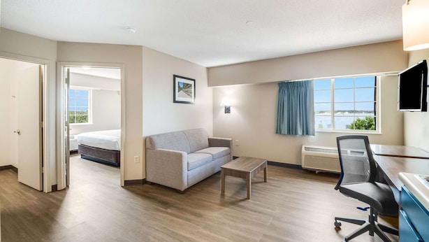 Habitación de hotel con cama, sofá, escritorio y ventana con vistas.