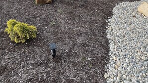 A Super 8 hotel with a brick facade, a covered entrance, and a landscaped area with mulch and rocks. - Super 8 by Wyndham Independence KS (Independence)