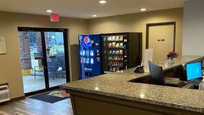 A reception area with a granite counter, a computer, a Pepsi vending machine, and a Coca-Cola vending machine. - Super 8 by Wyndham Independence KS (Independence)