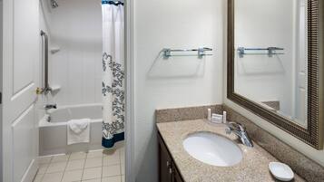 A bathroom with a bathtub, shower, and sink.