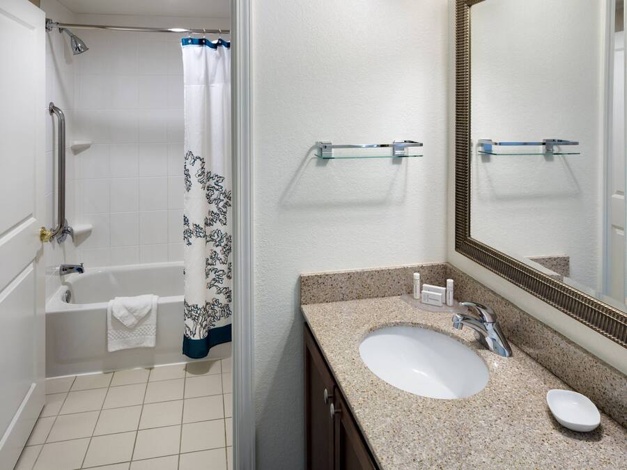 A bathroom with a bathtub, shower, and sink.