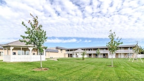 A residential building with a covered patio, a grassy lawn, and a playground. - Motel 6 York, NE (York)
