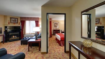 Een hotelkamer met een open haard, een bed, een bureau en een grote spiegel.