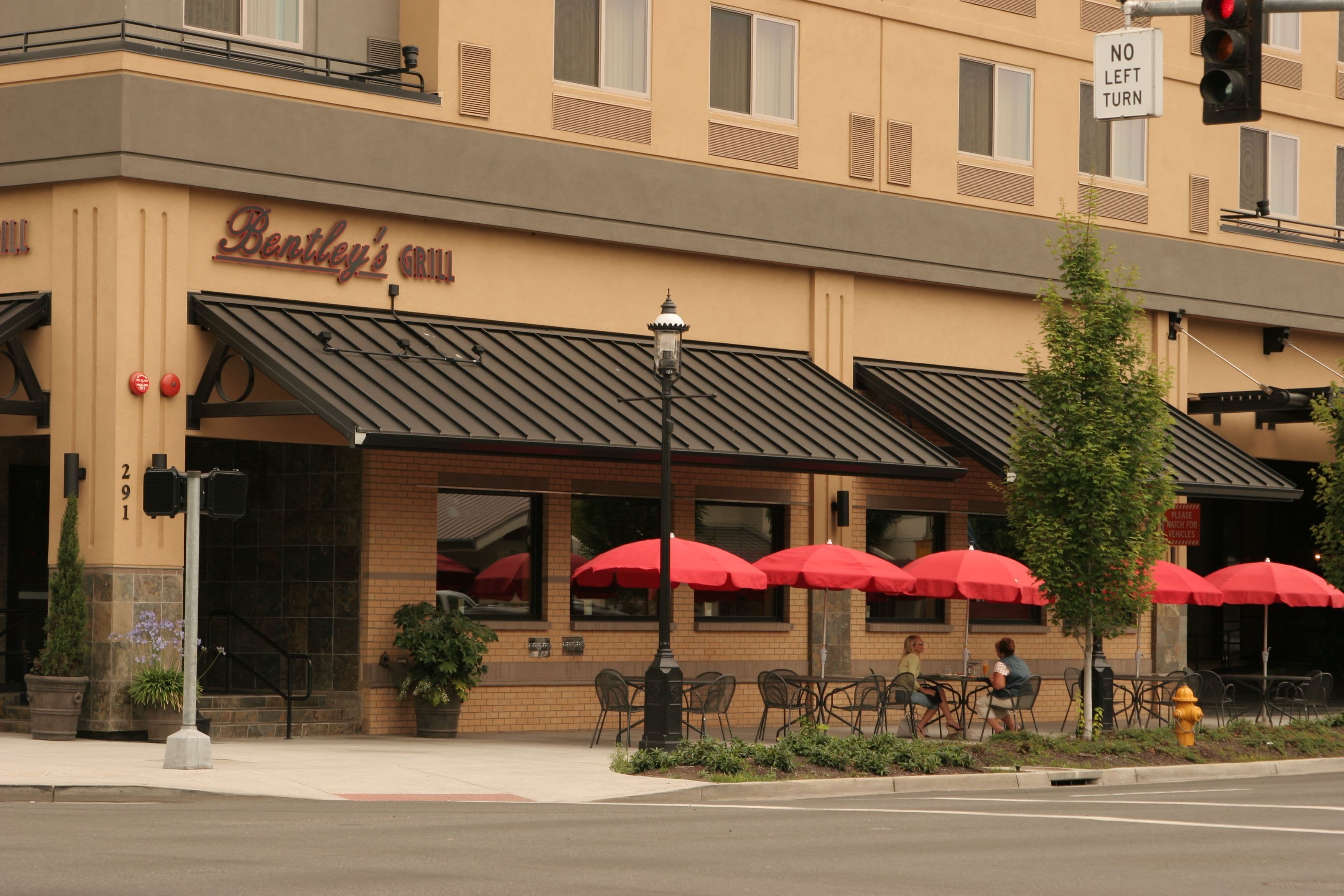 Un restaurant avec une terrasse et des parasols rouges.