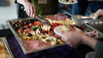 Un buffet proposant une variété de plats, notamment des viandes, des fromages et des légumes.