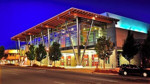 A modern building with a glass facade and a metal roof structure.