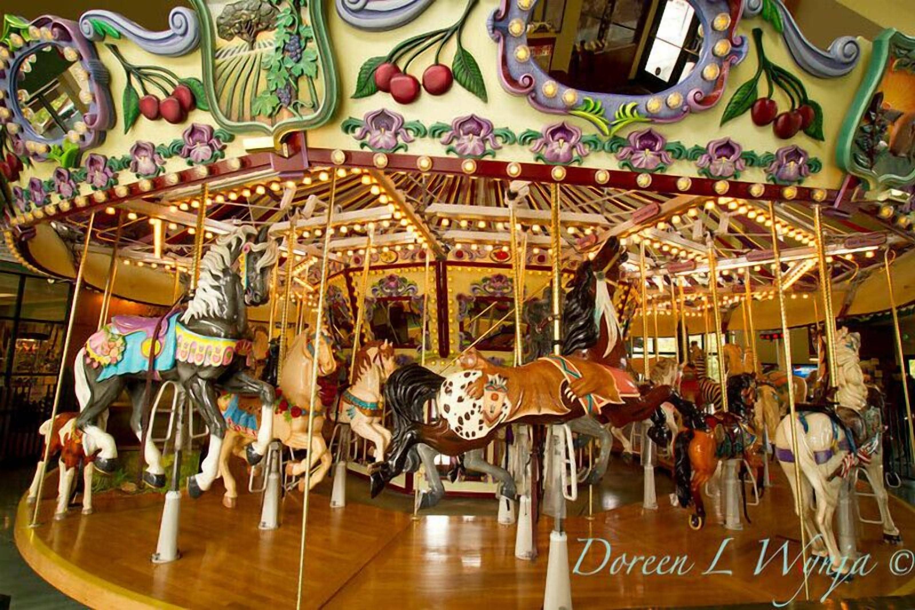 A carousel with ornate decorations and multiple horses.