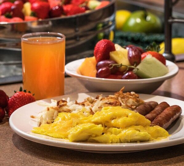 A breakfast plate with eggs, sausages, and hash browns.