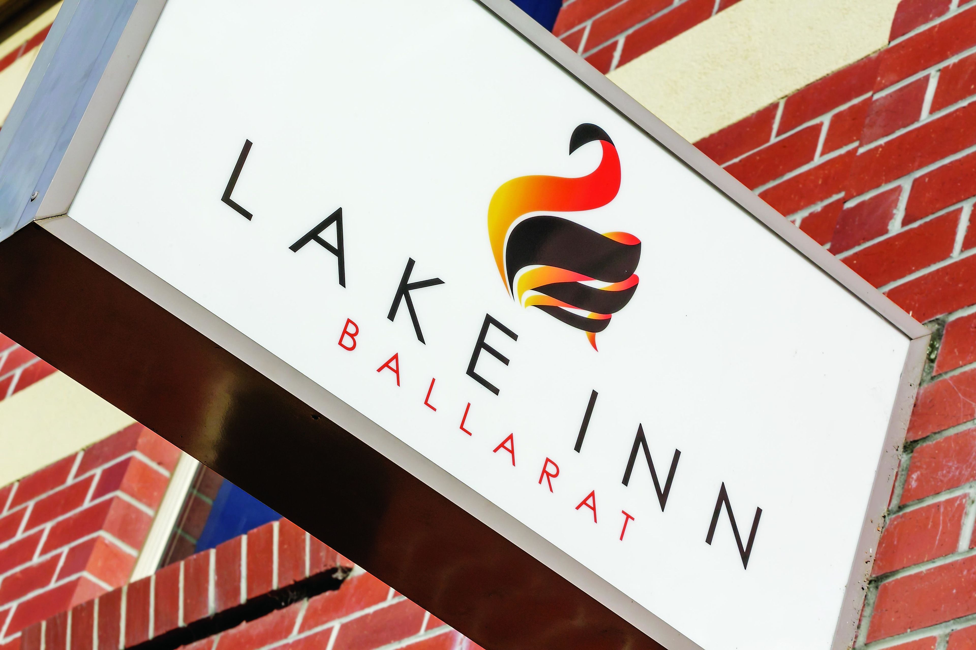 A sign for Lake Inn Ballarat with a stylized flame logo.
