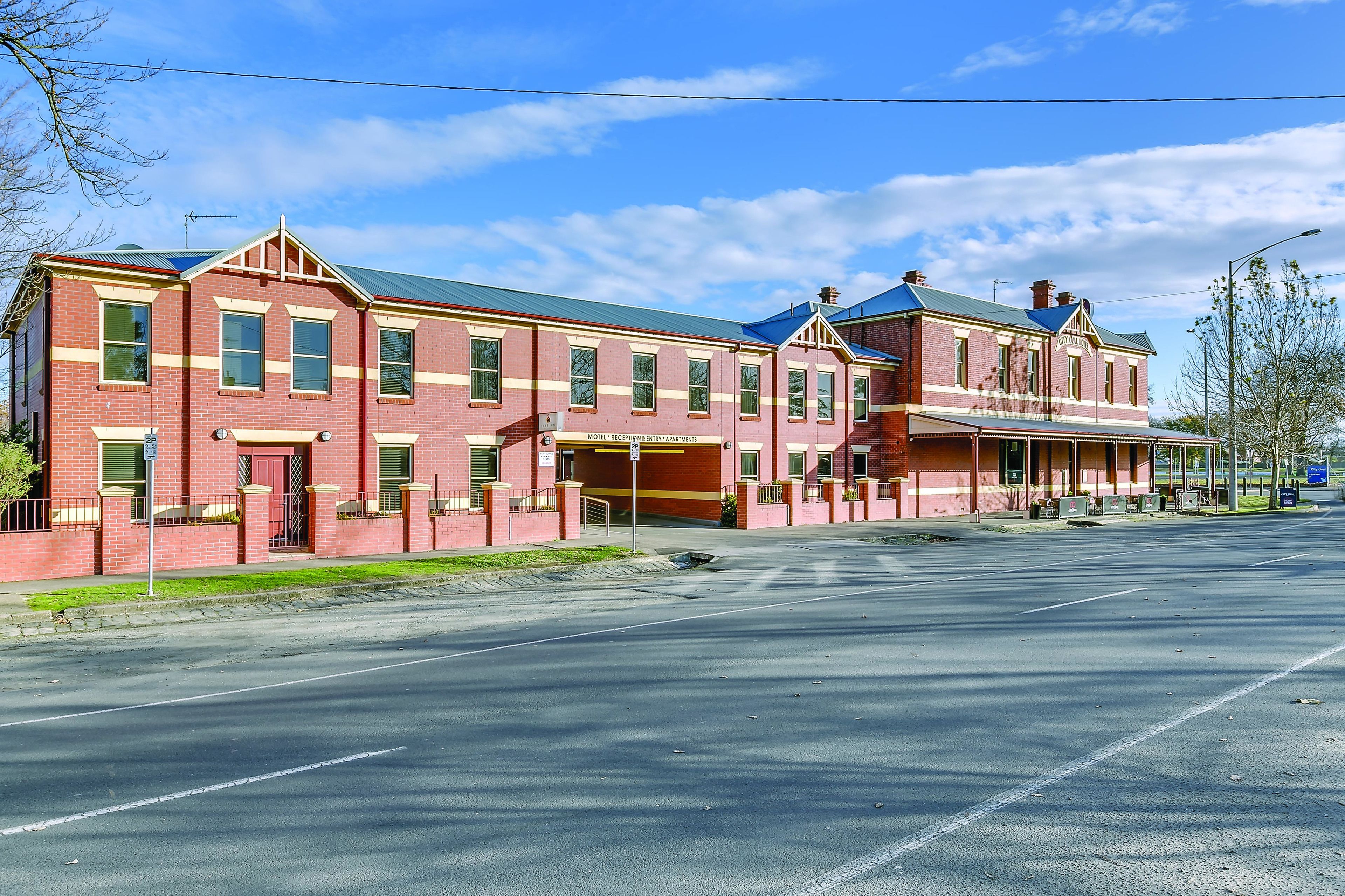 A large brick building with a flat roof and a central entrance.