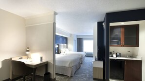 A hotel room with a desk, two beds, a small kitchenette, and a large window. - SpringHill Suites by Marriott Savannah Airport (Savannah)