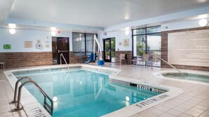 An indoor swimming pool with clear safety instructions, a lifeguard chair, and a pool lift. - SpringHill Suites by Marriott Savannah Airport (Savannah)