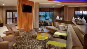 A modern hotel lobby with a seating area, a reception desk, and a large window offering a view of the outside. - SpringHill Suites by Marriott Savannah Airport (Savannah)
