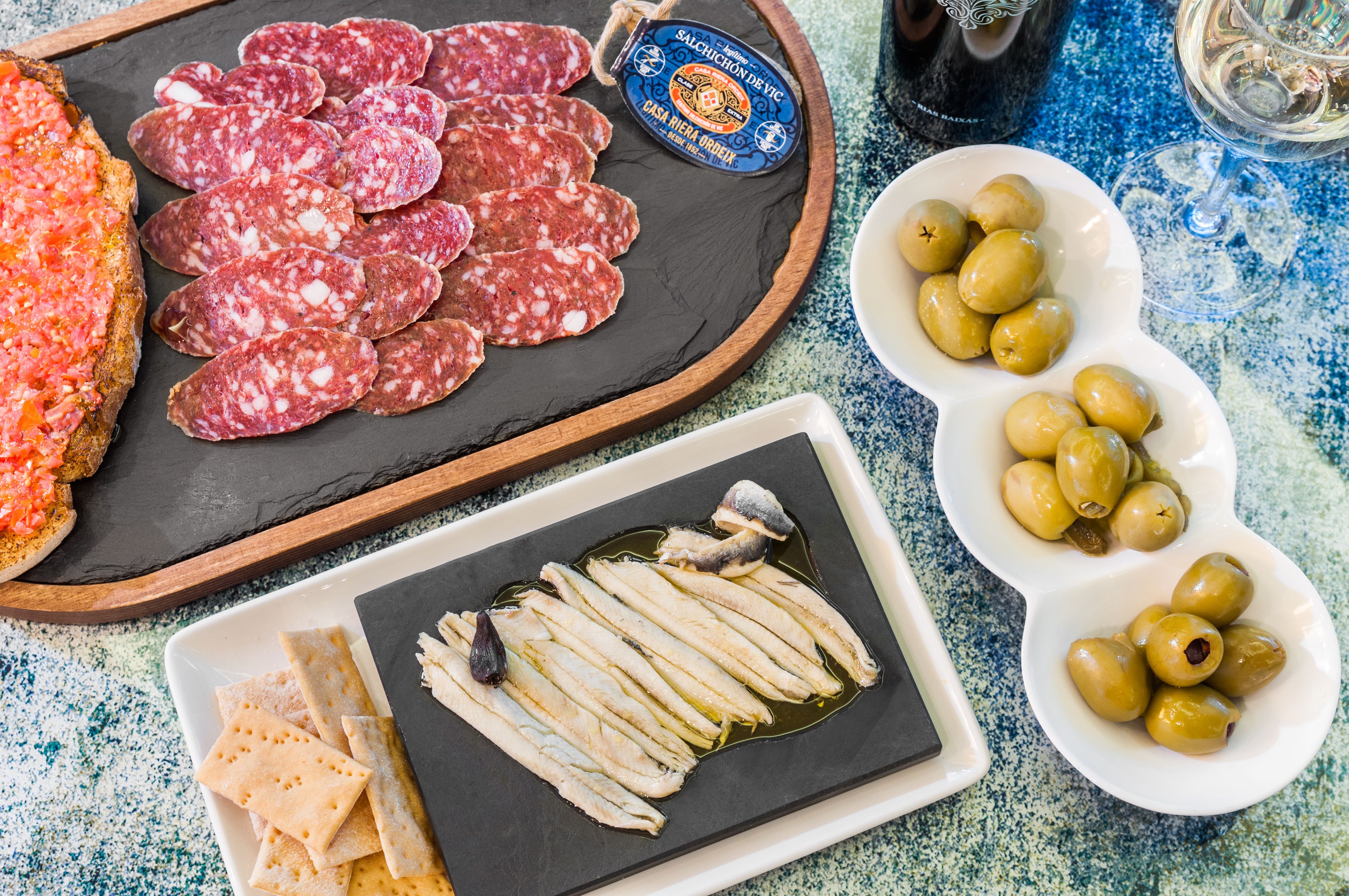 Un tagliere con salumi assortiti, olive e cracker.