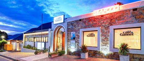 A building with a stone facade and large windows, labeled "Café Gannet."