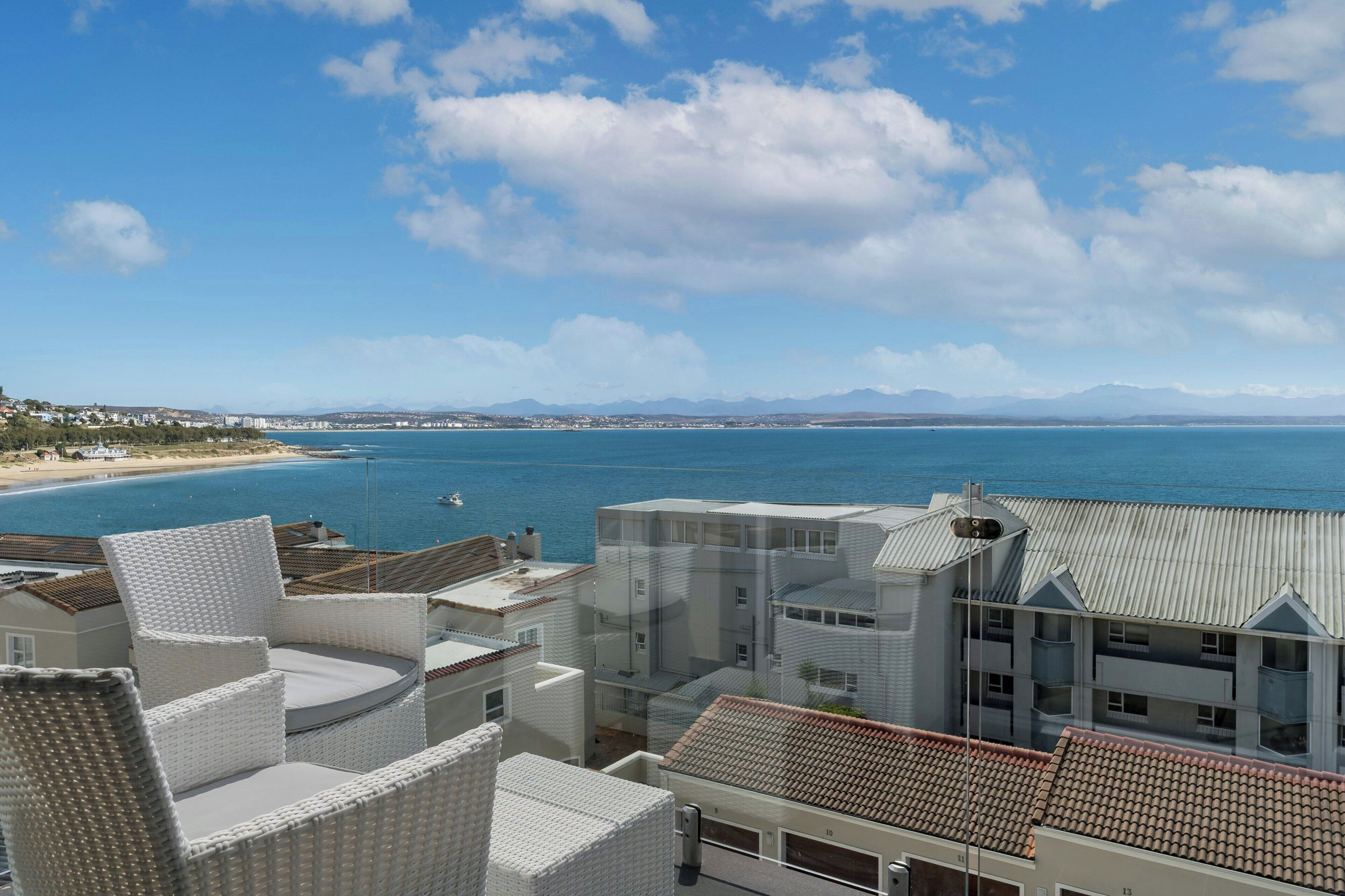Une vue sur la côte, avec des bâtiments, une plage et un ciel dégagé.