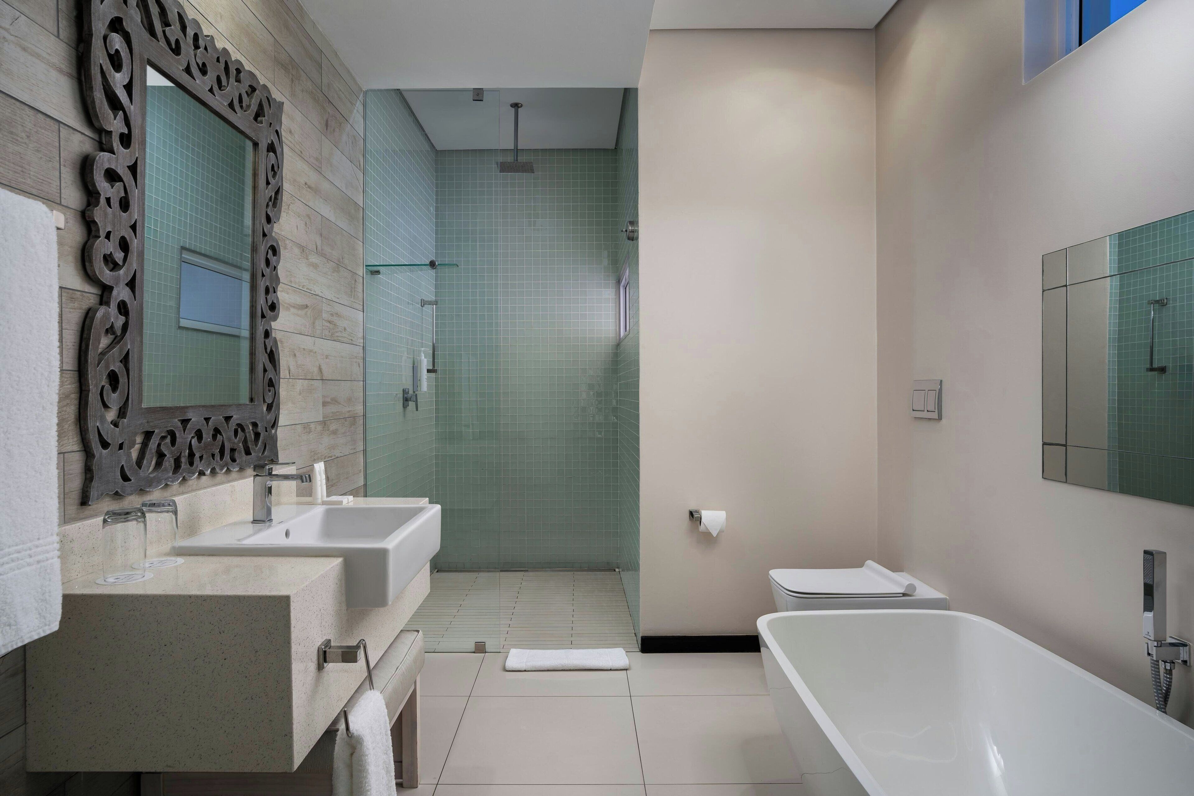 Un baño moderno con dos lavabos, una bañera y zona de ducha.