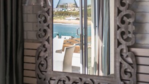 A mirror with an ornate frame reflecting a beach view, a hanging light fixture, and a door leading to an outdoor area. - Protea Hotel by Marriott Mossel Bay (Mossel Bay)