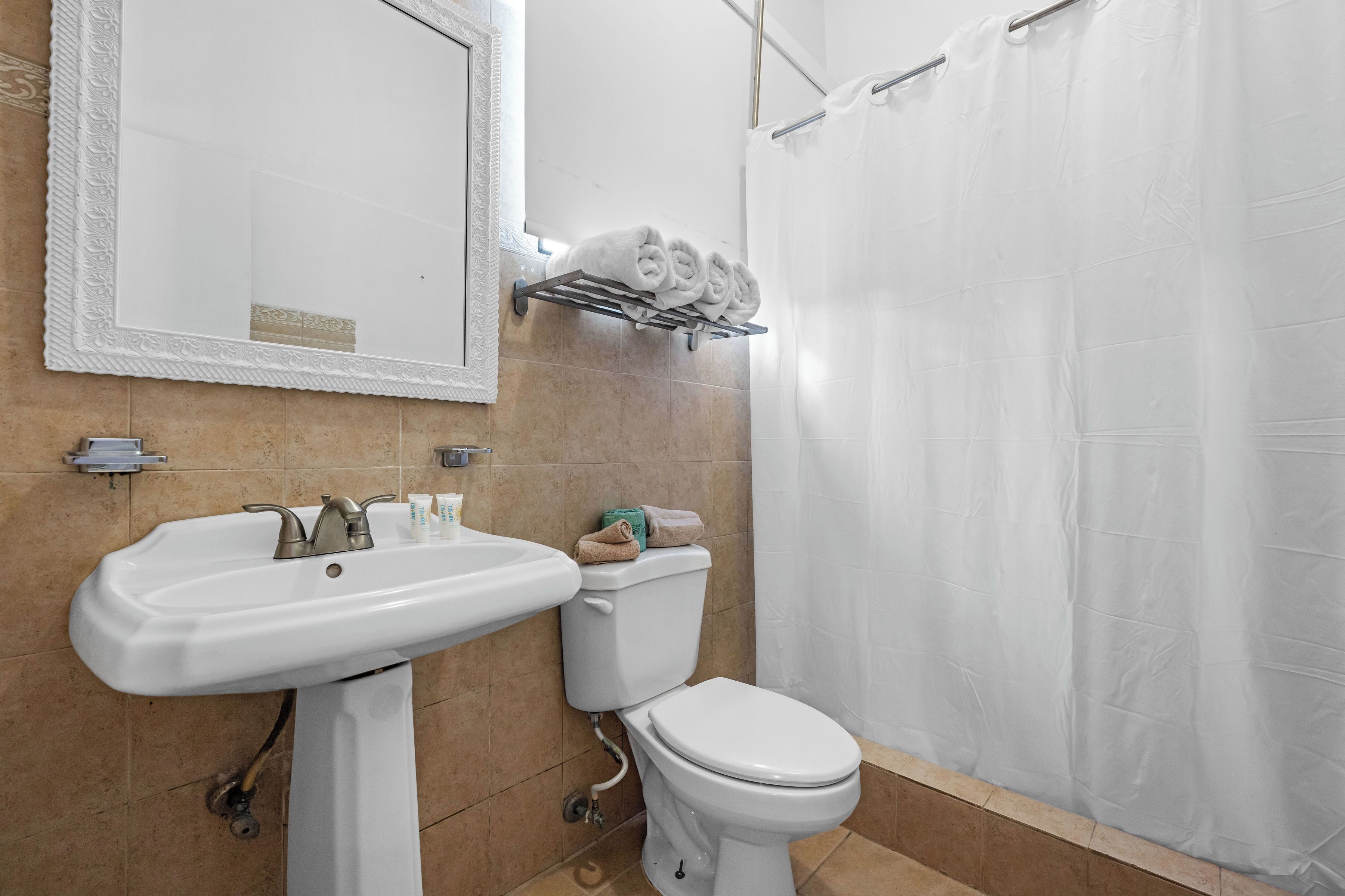Une salle de bain équipée d’un lavabo, de toilettes et d’un porte-serviettes.