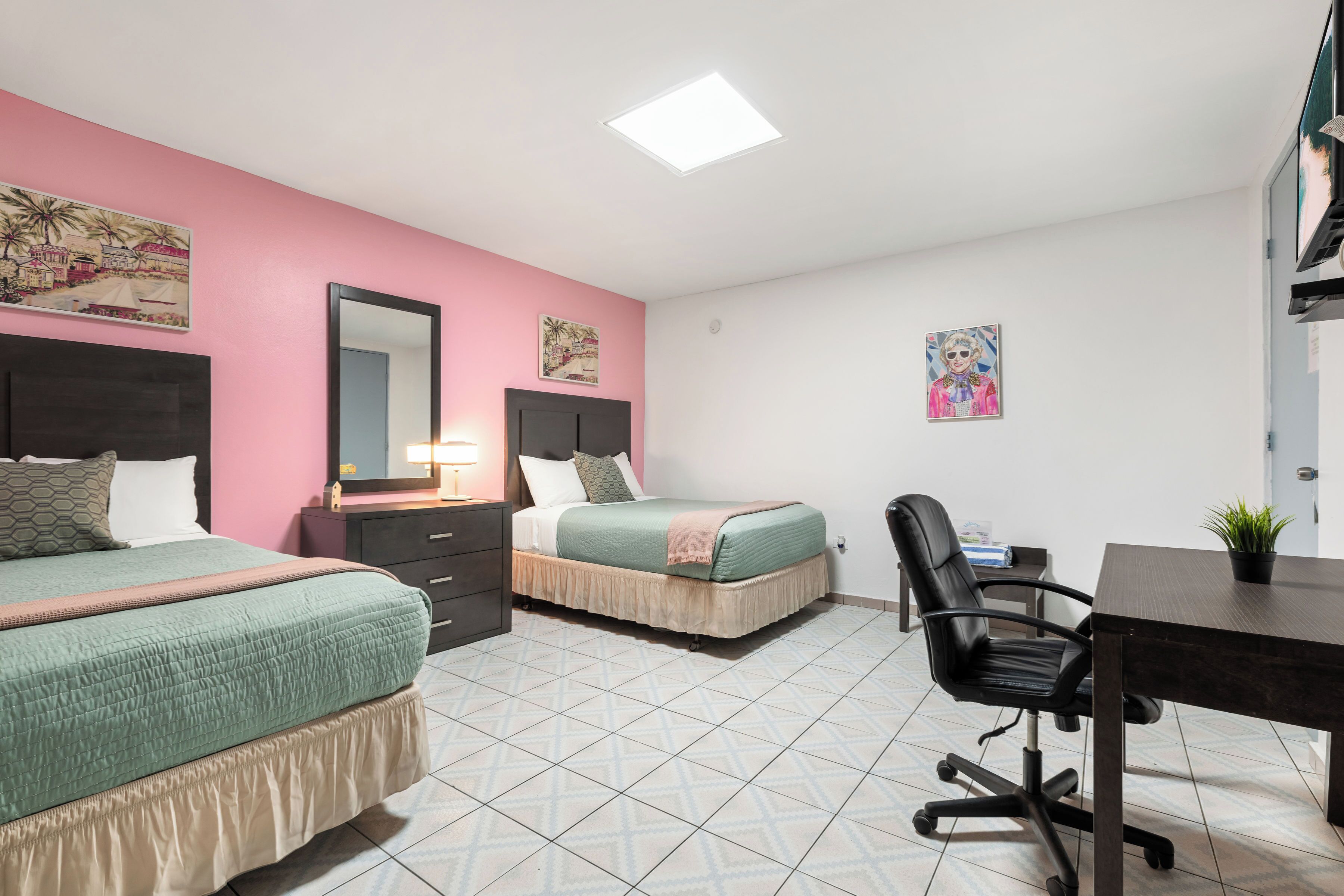 Un dormitorio con dos camas, un escritorio y una silla.