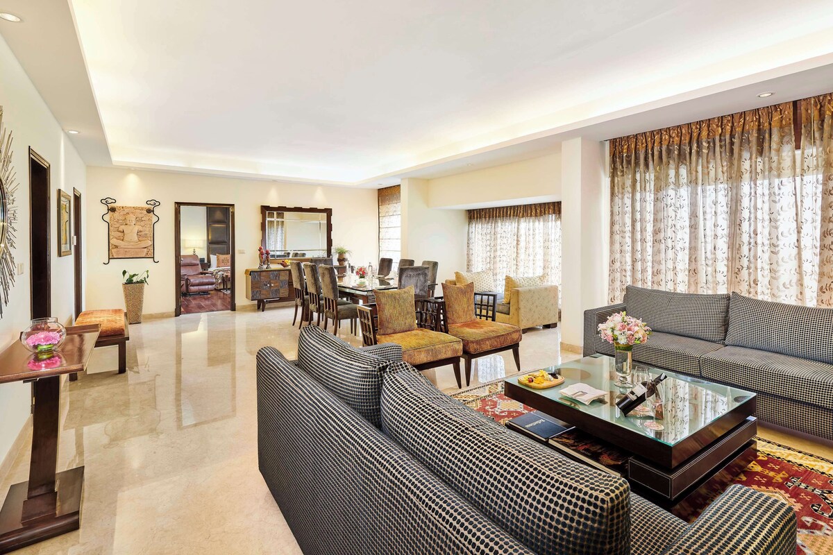 A spacious living area with a dining table, sofas, and a coffee table.