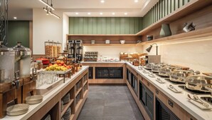 Una cocina moderna con una isla central, equipada con diversos electrodomésticos y alimentos.