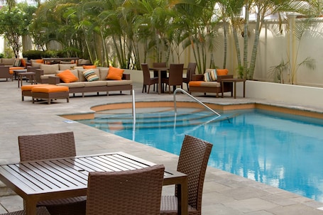Una piscina al aire libre, sillones reclinables de piscina