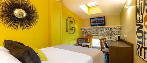 Habitación de hotel con cama, escritorio, silla, reloj de pared y tragaluz.