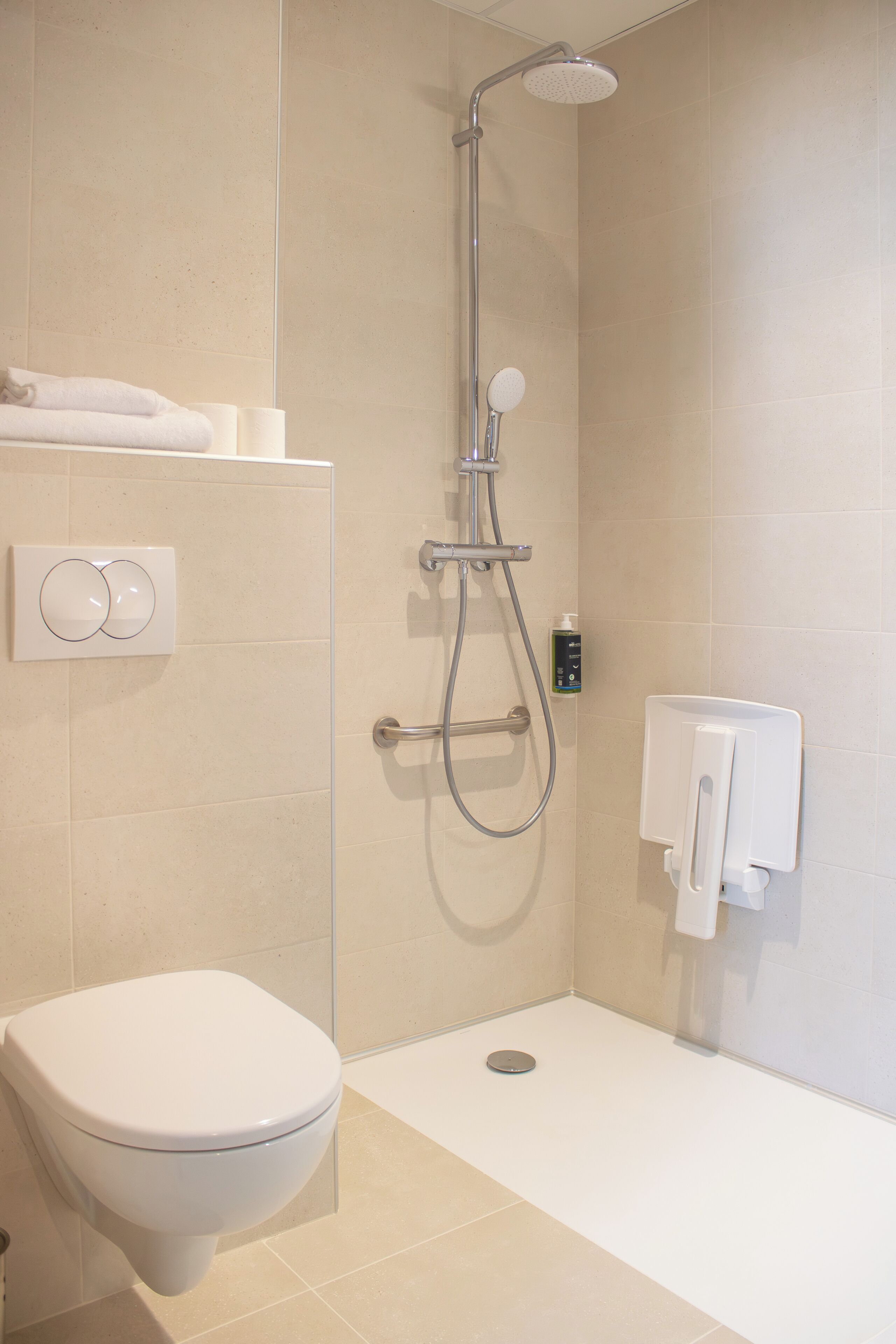 Un baño con inodoro, ducha y secamanos.