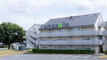 Un hotel de varios pisos con un diseño moderno, destacando un letrero con el nombre 'Campanile'.