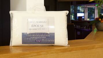 A package labeled "Déjà Marié(e)? Je vous épouse quand même!" on a wooden surface, with a vase of flowers in the background.