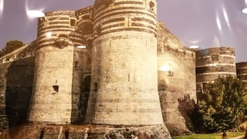 Un castillo de piedra histórico con dos torres destacadas y una entrada central.