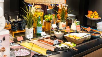 A buffet with various food options, including meats, cheeses, and fruits.