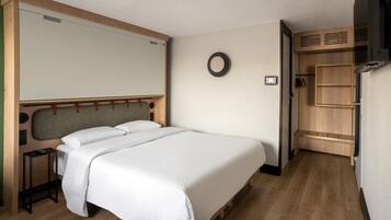 Een netjes ingerichte slaapkamer met een bed, nachtkastje en een inbouwkast.