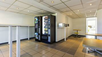 A modern indoor space with vending machines, a microwave, and a table.