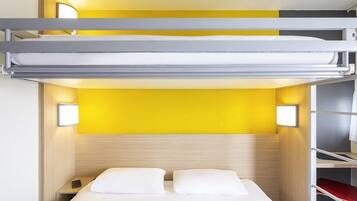 A bunk bed with a yellow wall behind it, a bedside table with a phone, and a red chair.