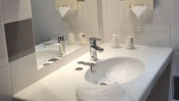 Une salle de bain moderne avec un lavabo blanc, un miroir et une serviette.