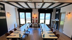 A conference room with long tables, chairs, and a welcome sign. - Campanile NATURE - Colmar Parc des Exposition (Colmar)