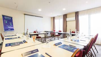 Un salón de conferencias con mesas, tarjetas de identificación y un cartel de bienvenida.