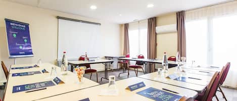 Un salón de conferencias con mesas, tarjetas de identificación y un cartel de bienvenida.