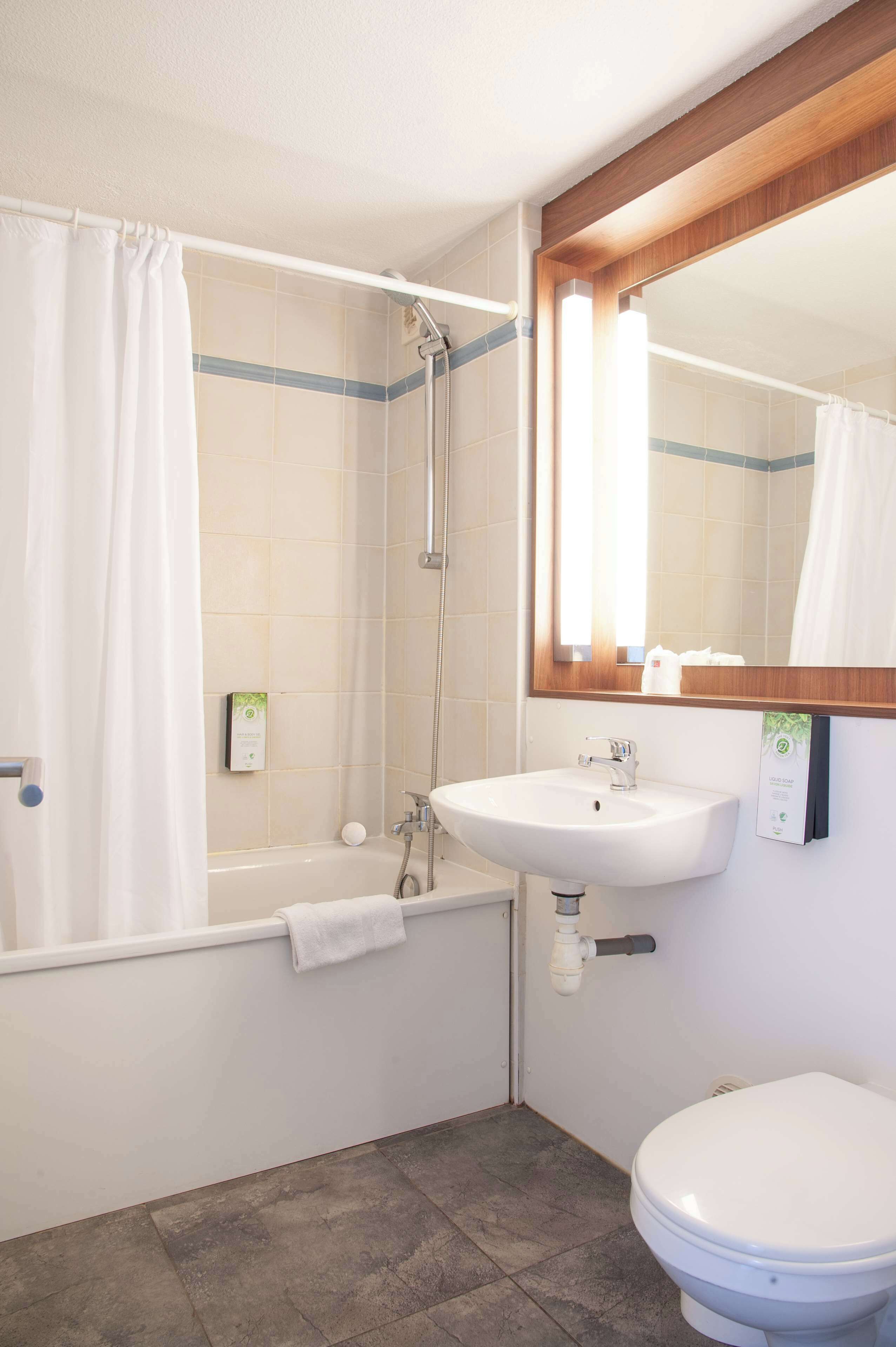 Een badkamer met een bad, een wastafel en een toilet.