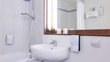 Un baño con un lavabo blanco, ducha, espejo y toallero.