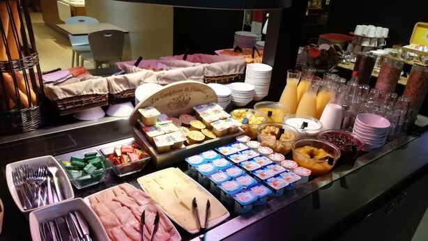 Un bufé con diversos alimentos, como frutas, quesos y yogur.