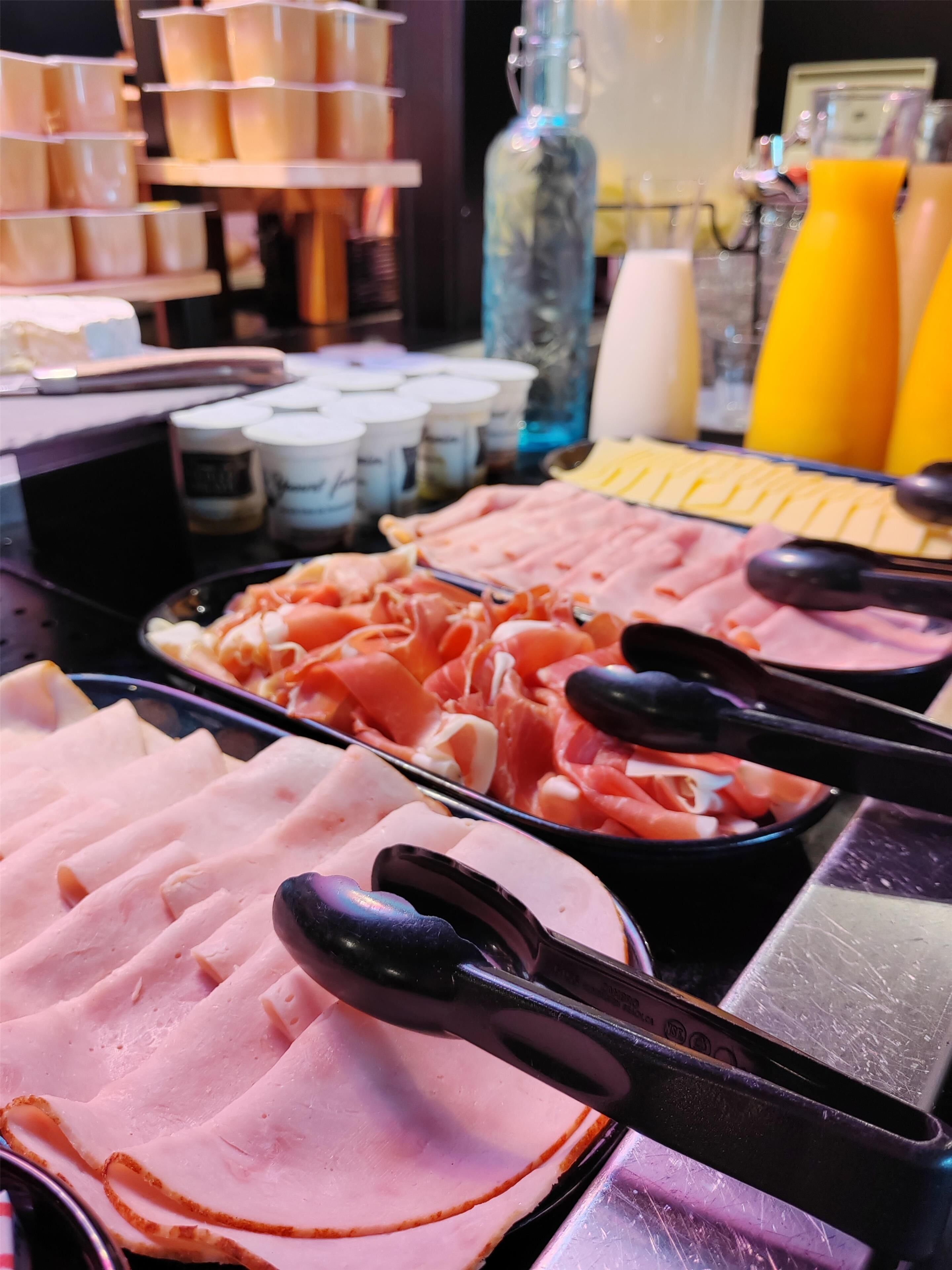 A buffet with various meats and condiments.